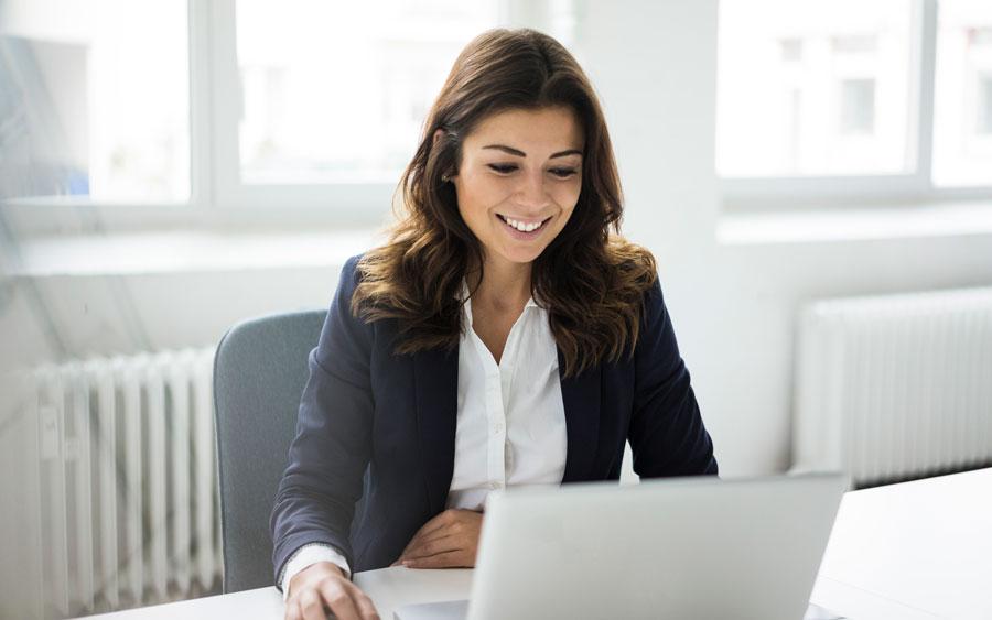 Freundliche Mitarbeiterin vor Notebook