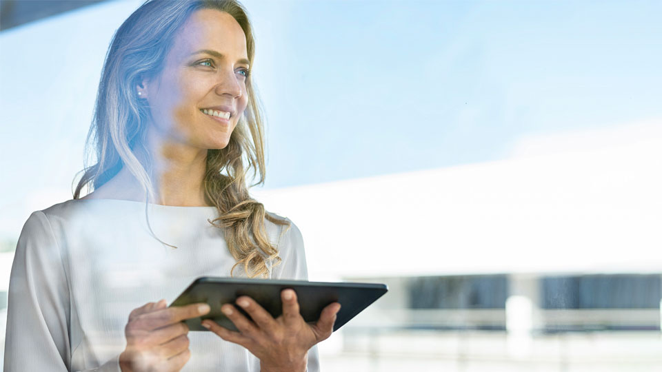 Frau haelt Tablet in der Hand