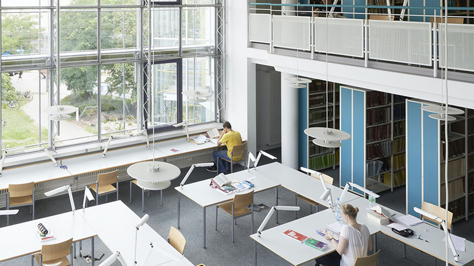 Picture of the library of the FAU University Erlangen-Nuremberg with learning students.