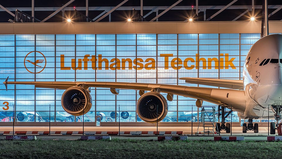 A Lufthansa aircraft is parked in a hangar.