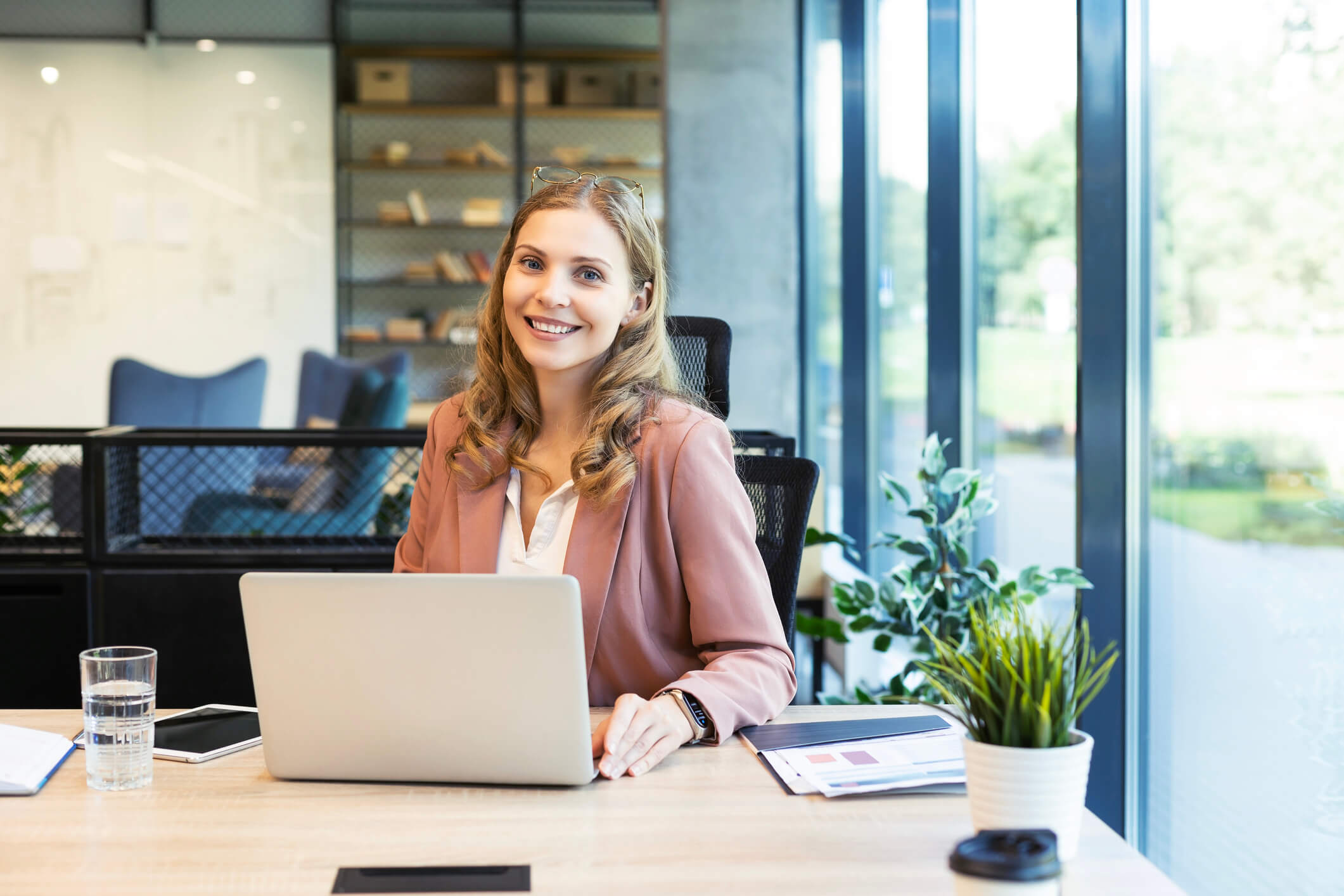 Lächende Dame arbeitet an Laptop