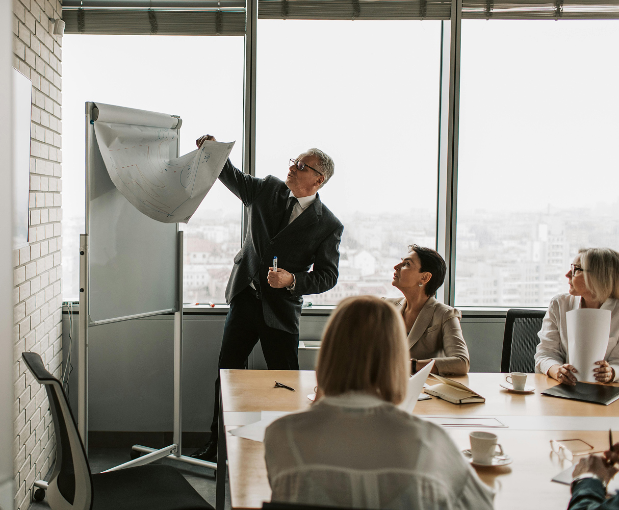 People in meeting room looking at a whiteboard