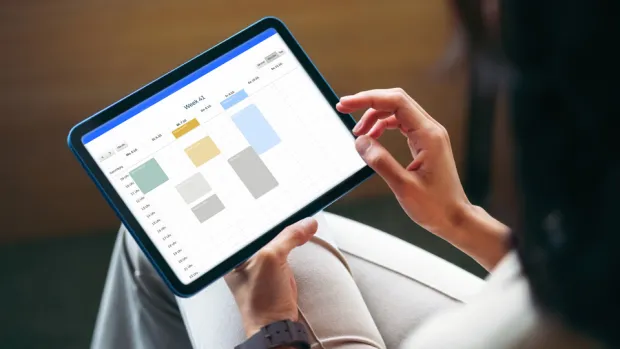 Person betrachtet auf einem Tablet einen digitalen Kalender zur strukturierten Planung von Aufgaben und Terminen im Rahmen eines digitalen Fristenmanagements.