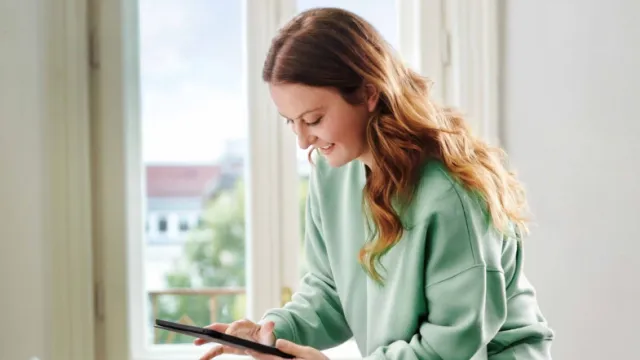Frau schaut auf ihr Smartphone TODO